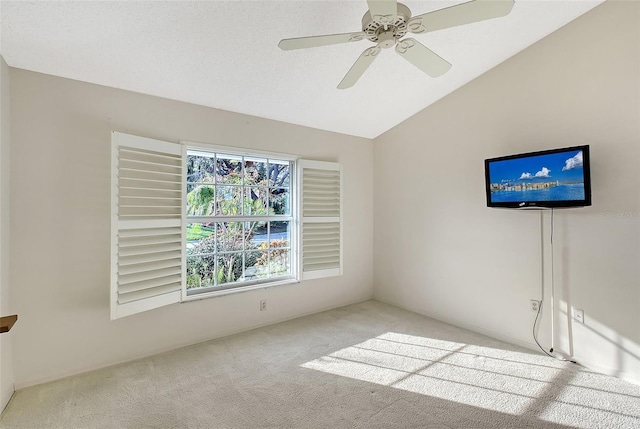 carpeted empty room featuring lofted ceiling and ceiling fan