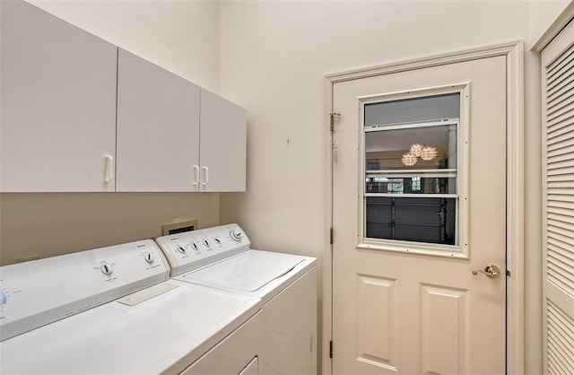 clothes washing area with washer and clothes dryer and cabinets