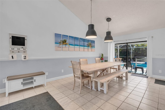 tiled dining space with vaulted ceiling and a textured ceiling