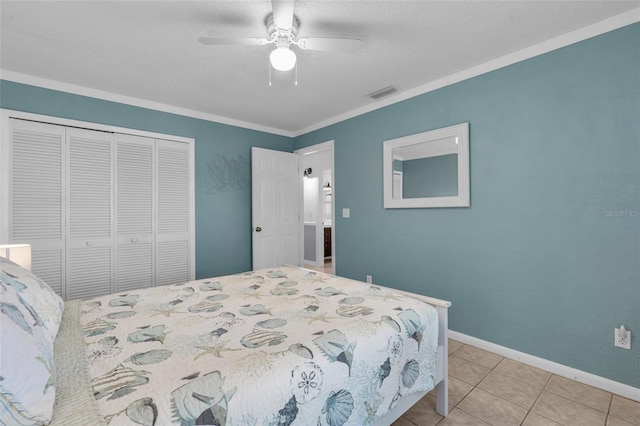 tiled bedroom featuring ceiling fan, a closet, and crown molding