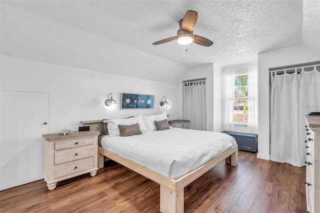 bedroom with dark wood-type flooring, ceiling fan, lofted ceiling, and a textured ceiling