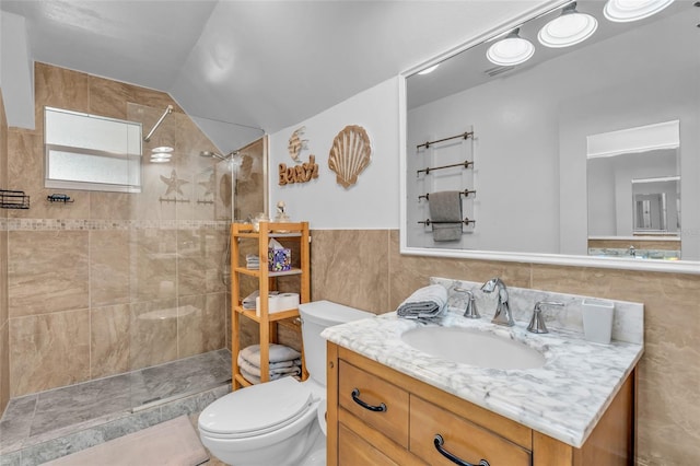 bathroom with toilet, vanity, vaulted ceiling, and tiled shower