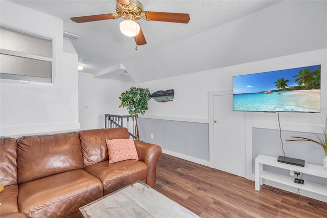 living room featuring ceiling fan, wood-type flooring, and a textured ceiling