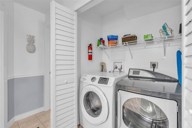 clothes washing area with light tile patterned floors and washing machine and dryer