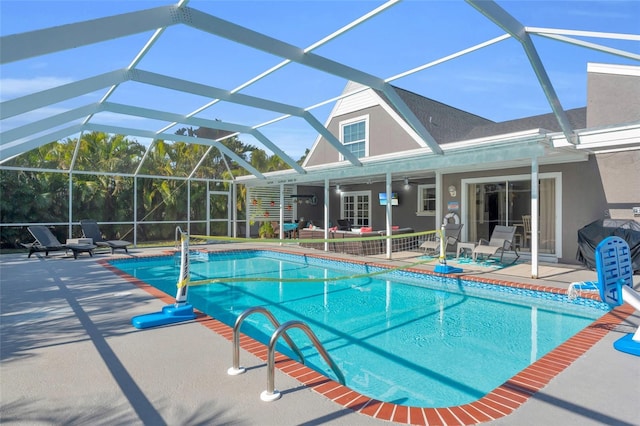 view of pool with a patio area and glass enclosure