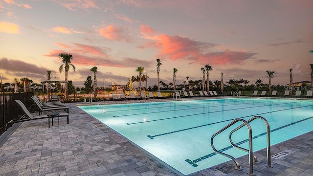 pool at dusk with a patio