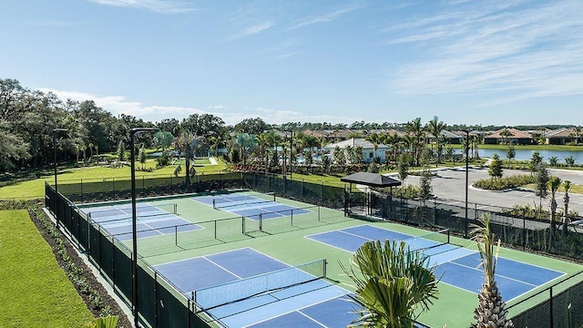 view of tennis court with a water view