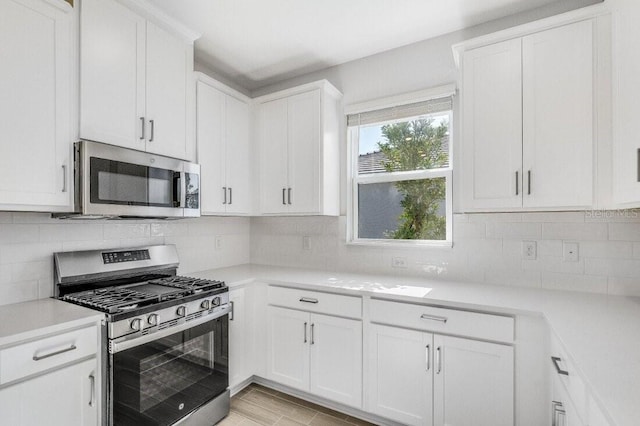 kitchen with appliances with stainless steel finishes, white cabinetry, and decorative backsplash