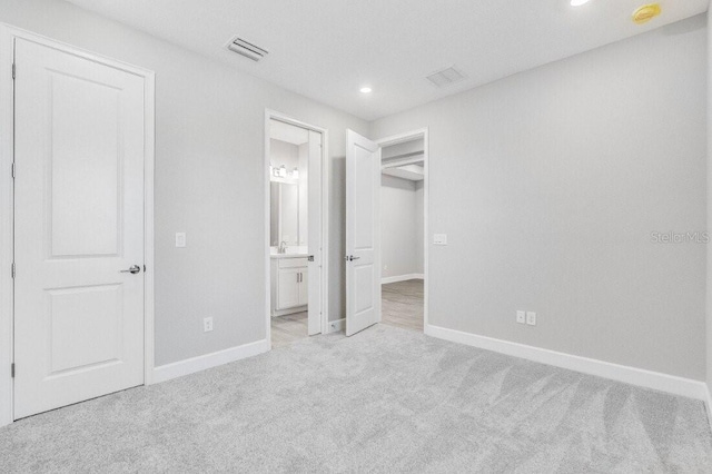 unfurnished bedroom featuring baseboards, recessed lighting, visible vents, and light colored carpet