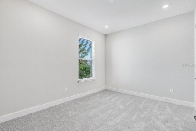 carpeted empty room featuring recessed lighting and baseboards