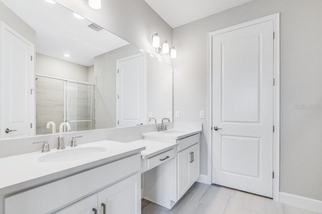 full bath with double vanity, a stall shower, visible vents, and a sink