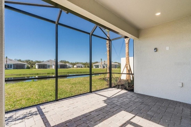 unfurnished sunroom featuring a healthy amount of sunlight and a water view