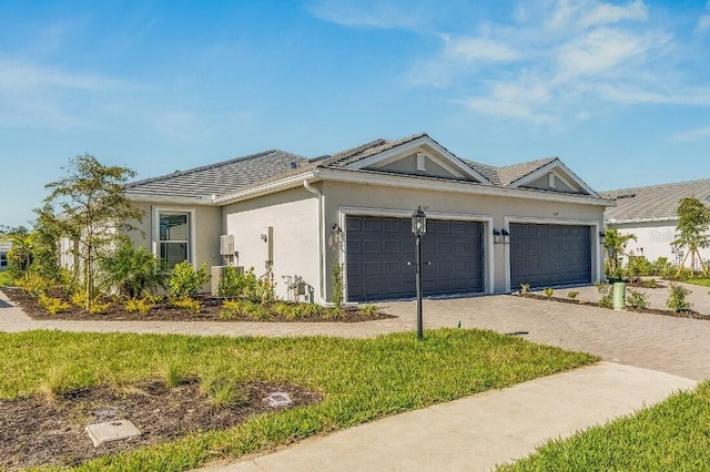 ranch-style house with decorative driveway, an attached garage, and stucco siding