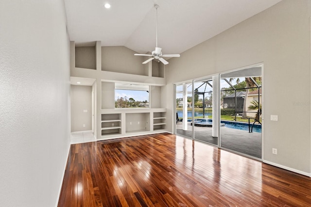 unfurnished living room with hardwood / wood-style flooring, high vaulted ceiling, and ceiling fan