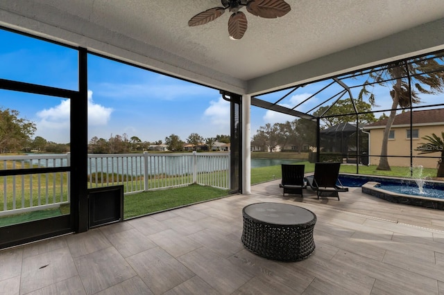 sunroom / solarium with ceiling fan and a water view