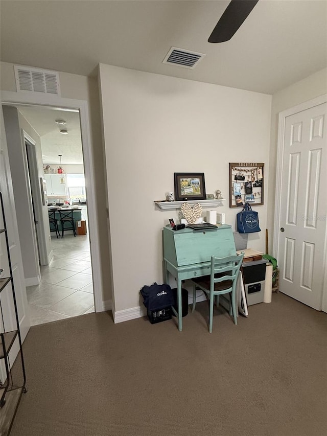 carpeted office space with ceiling fan