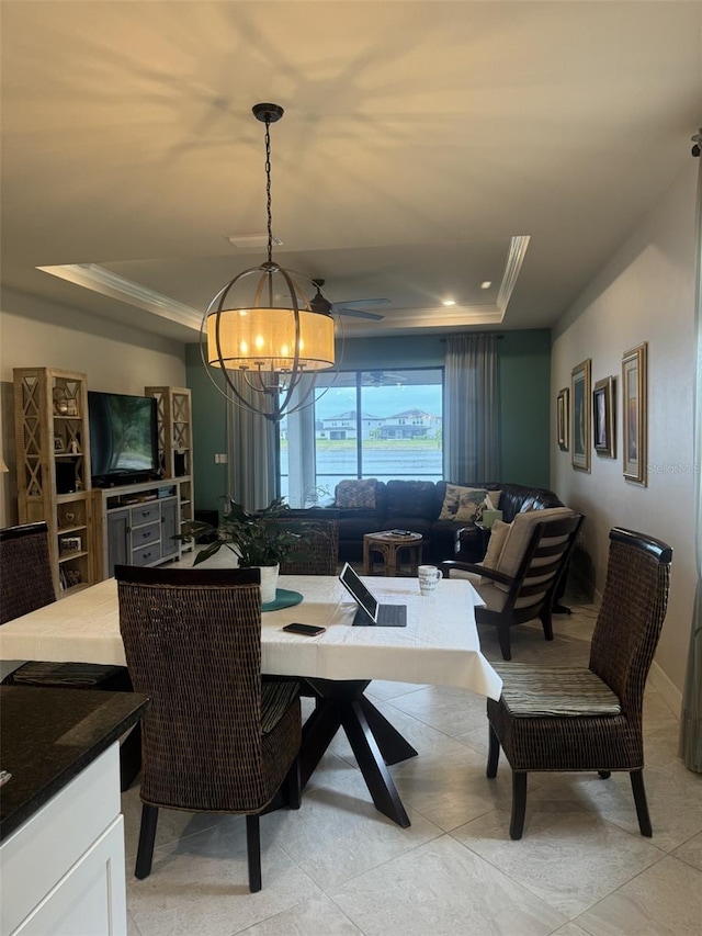 tiled dining room with crown molding, a notable chandelier, and a tray ceiling