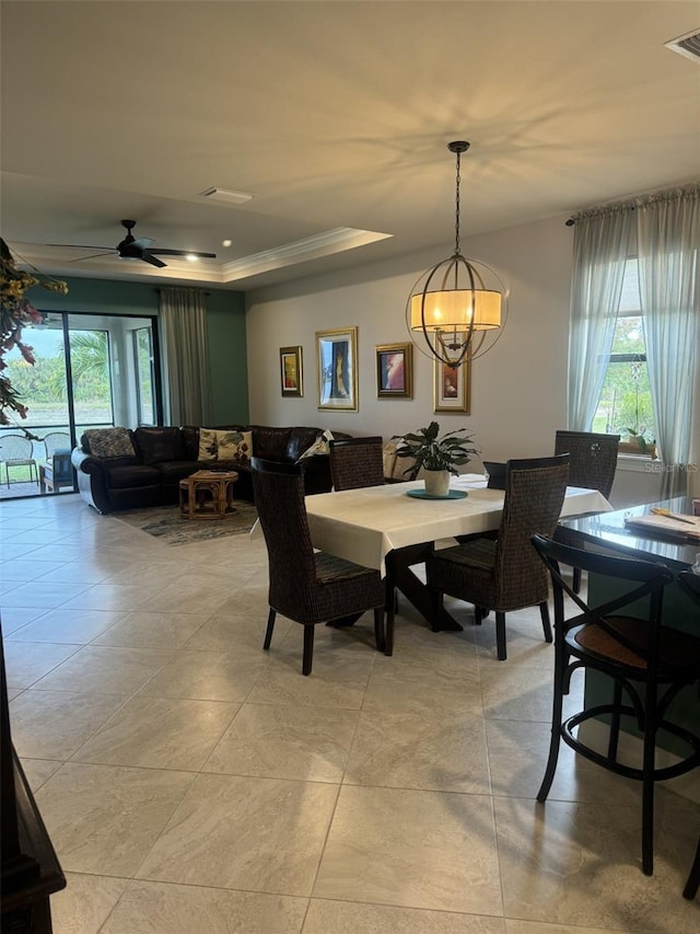 tiled dining area featuring a tray ceiling and ceiling fan