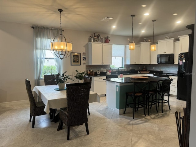 kitchen with pendant lighting, white cabinets, and black appliances