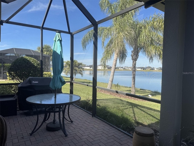 sunroom featuring a water view