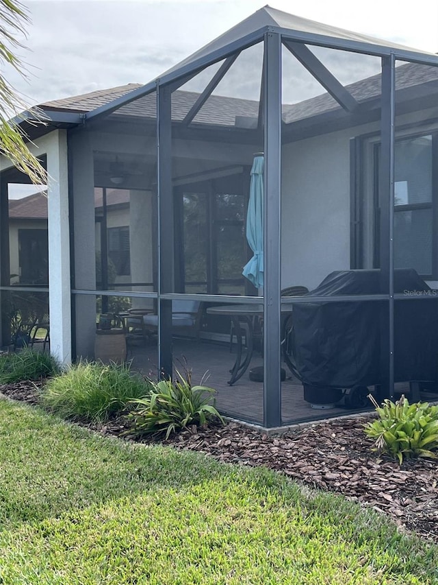 view of property exterior with a lanai and a patio