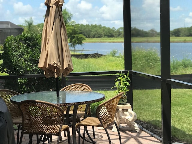 sunroom / solarium featuring a water view