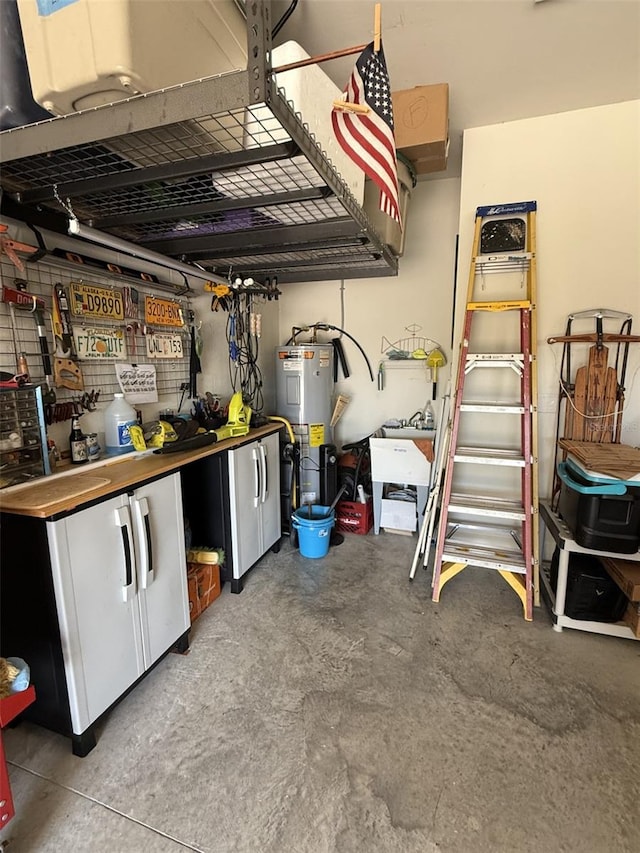 garage with a workshop area, electric water heater, and white fridge