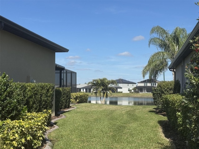 view of yard with a water view and a lanai