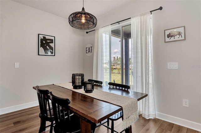 dining space with hardwood / wood-style floors and a healthy amount of sunlight