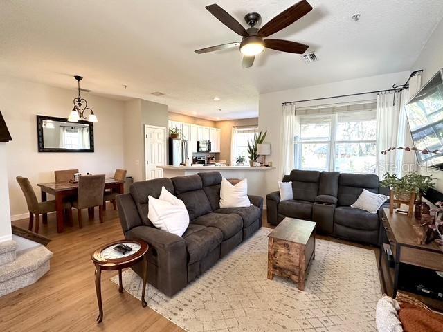 living room with ceiling fan and light hardwood / wood-style flooring