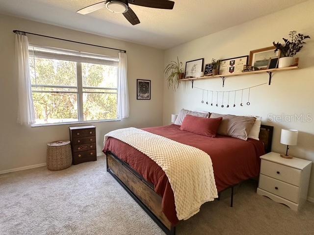 bedroom featuring ceiling fan and light carpet