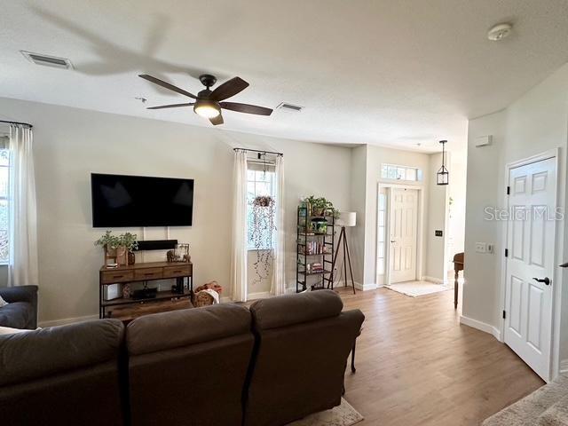 living room featuring ceiling fan and light hardwood / wood-style floors