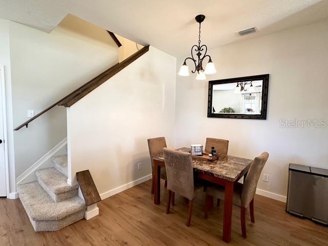 dining room with dark hardwood / wood-style floors and an inviting chandelier