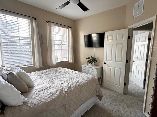 bedroom featuring light carpet and ceiling fan