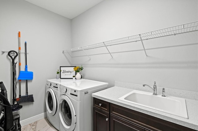 washroom with sink, cabinets, and washing machine and dryer