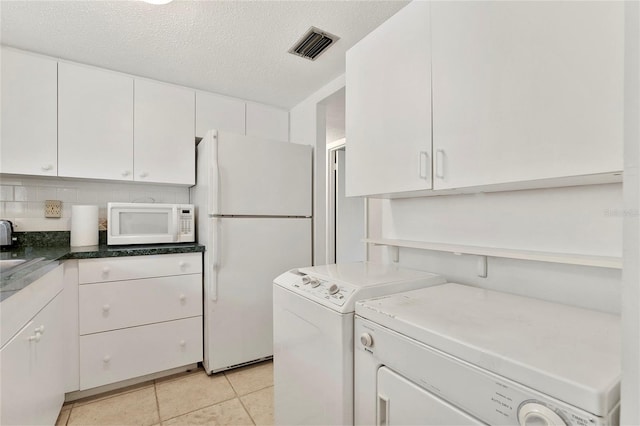 kitchen with white cabinetry, white appliances, and separate washer and dryer