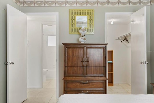 interior space featuring light tile patterned floors and ensuite bath