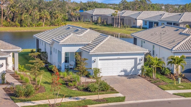 view of front of home with a garage, a water view, and a front yard