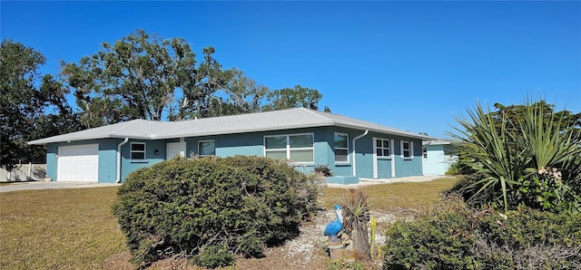 single story home featuring a garage and a front lawn