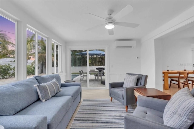 living room featuring ceiling fan and a wall unit AC