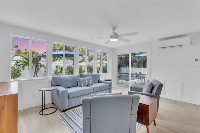 living room featuring ceiling fan, light hardwood / wood-style floors, and a wall mounted AC