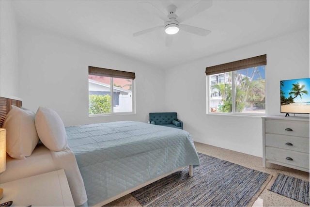 bedroom with ceiling fan and multiple windows