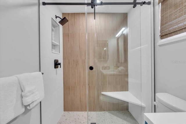 bathroom with toilet and a shower with shower door