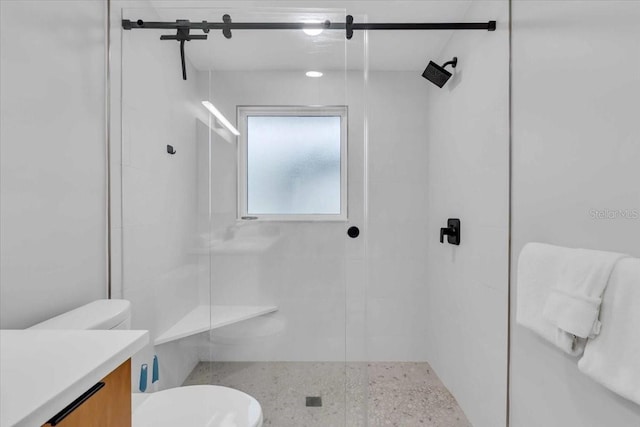 bathroom with toilet, vanity, and a shower with door