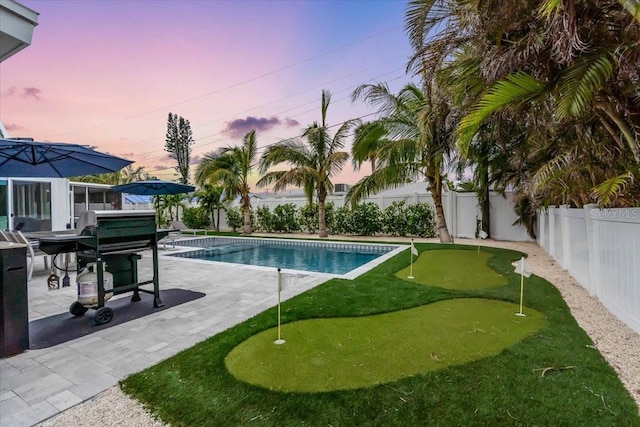 pool at dusk with a patio