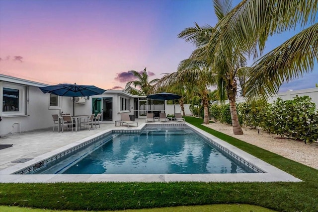 pool at dusk featuring a patio area