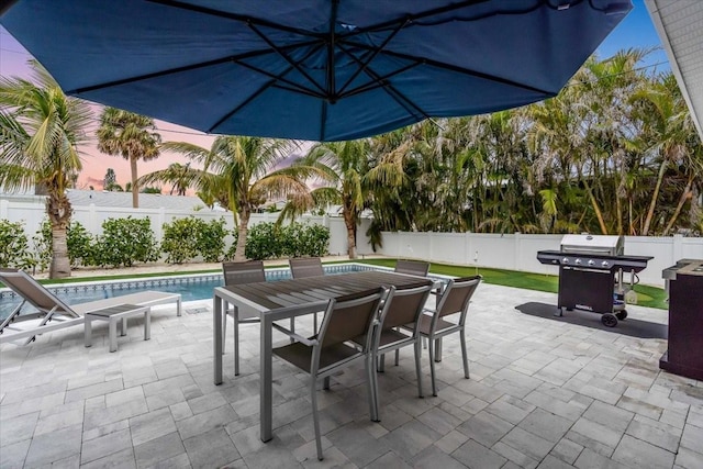 view of patio featuring a fenced in pool and area for grilling