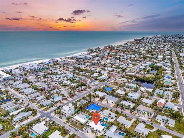 aerial view at dusk featuring a water view