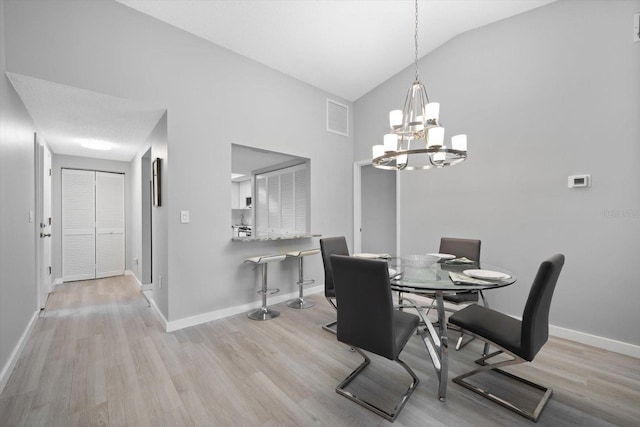 dining space featuring vaulted ceiling, a chandelier, and light wood-type flooring