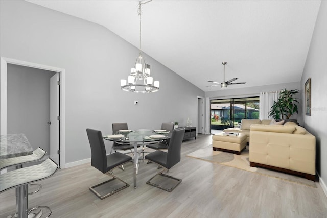 dining room featuring ceiling fan with notable chandelier, high vaulted ceiling, and light wood-type flooring